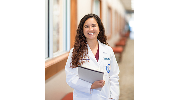 student in lab coat with a notepad