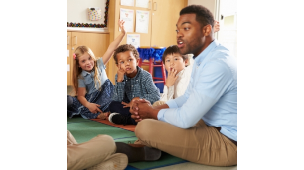 teacher with children sitting on a rug
