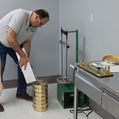 man pouring stones into a cylinder