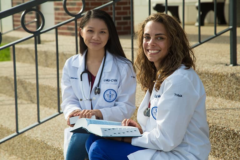 two students smiling on stairs