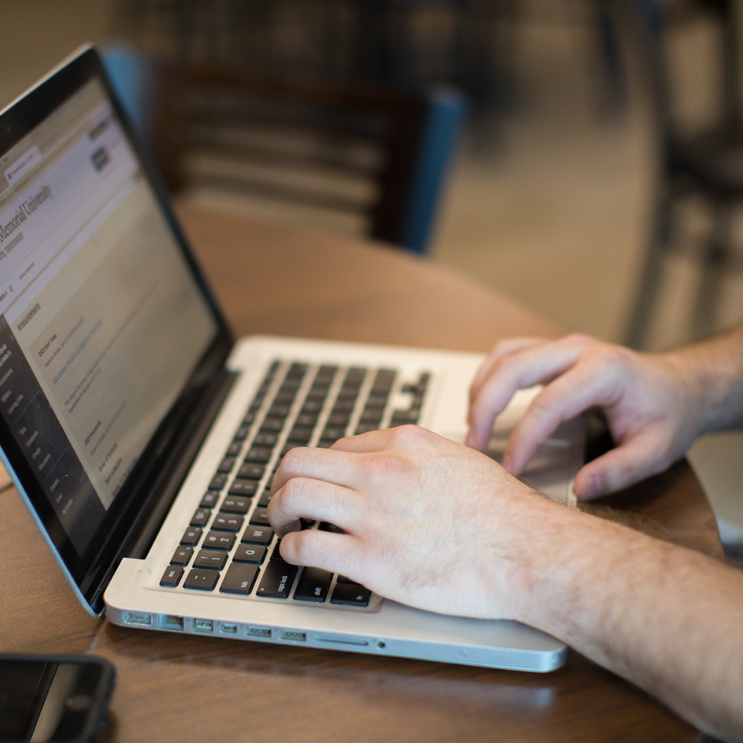 student typing on a laptop