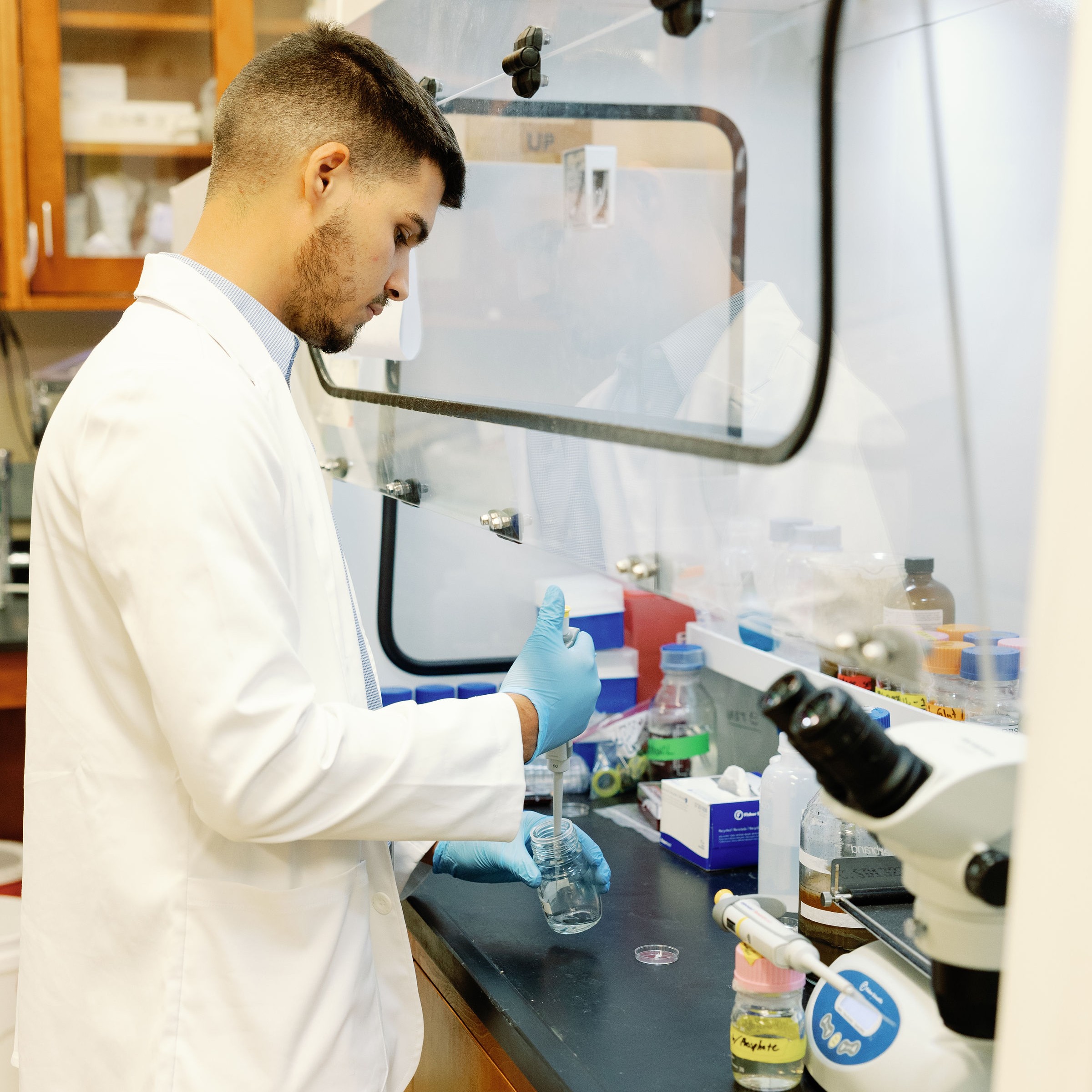 a student in a lab using a pipette