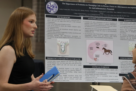 a dental student with a poster presentation