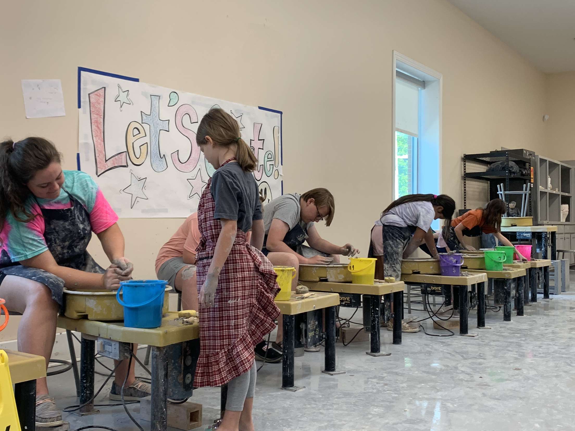 Clay pots for kids participants using the pottery wheels all in a line. 