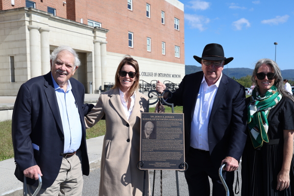 officials posing with plaque at ceremony