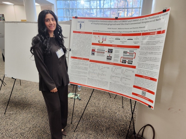 student researcher with poster