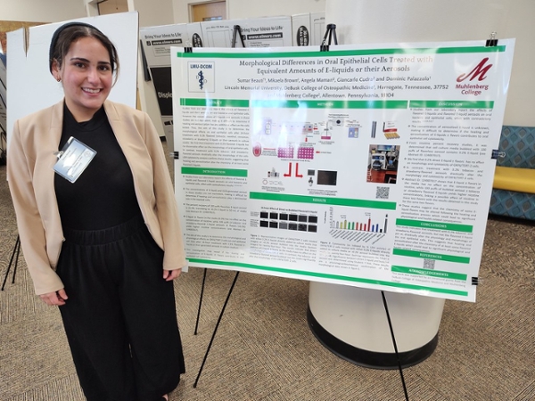 student researcher with poster 