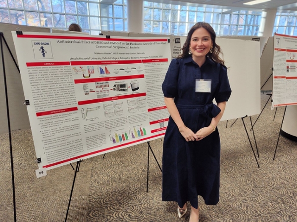 student researcher with poster