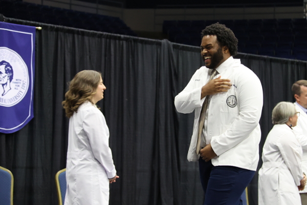 DCOM student receiving white coat