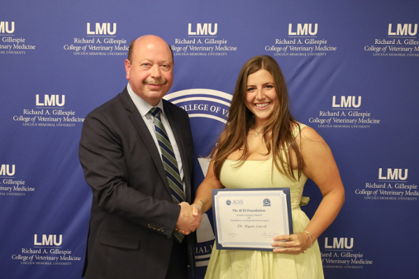 Dr. Evans and Ryan Lurch shaking hands and smiling