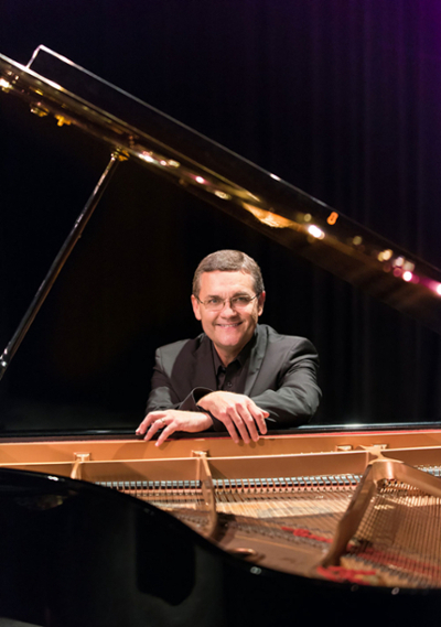 Man sitting at a grand piano.