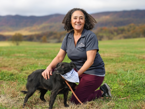 Dr. Arendse with a dog in front of the mountains
