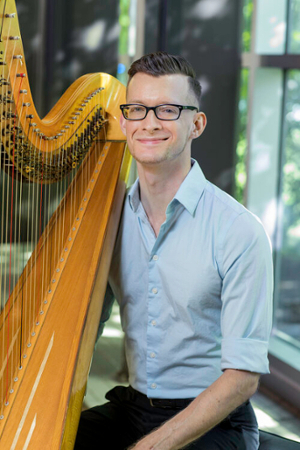 Joseph Rebman sits with his harp.