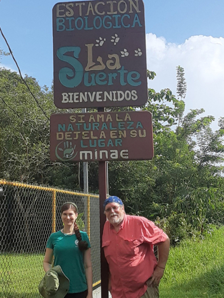 Man and woman standing at sign.