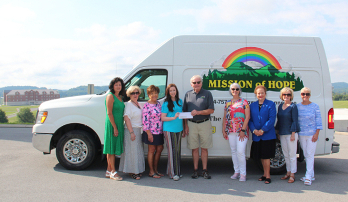 Group of Women of Service women presenting Mission of Hope Executive Director Emmette Thompson a donation.