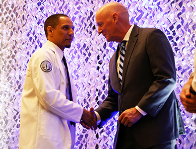 DCOM student receiving white coat