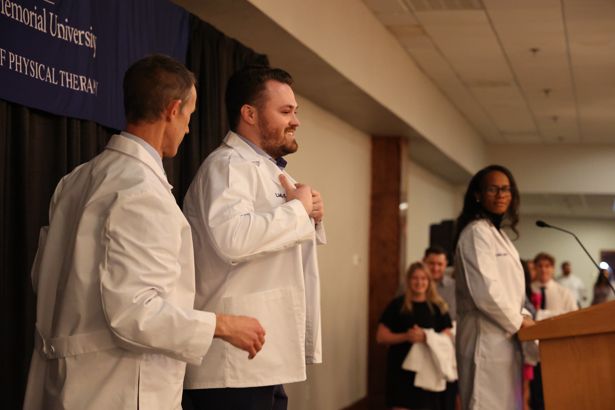 student being coated on stage