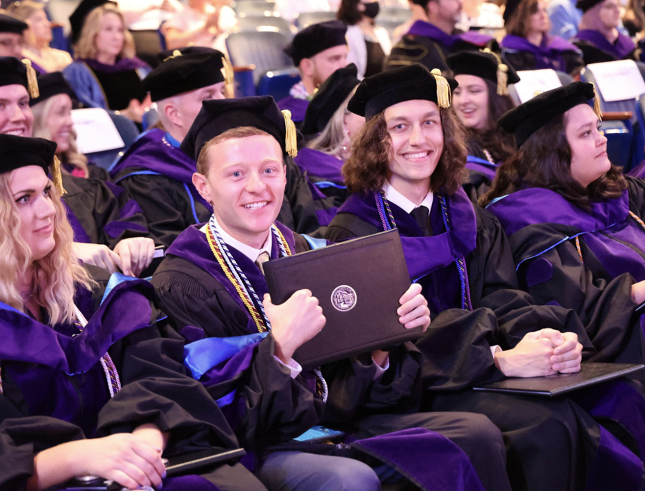 Law graduates holding diplomas