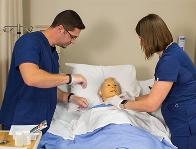 nursing students working on simulation mannequin 