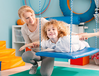 Occupational Therapist working with patient on a swing