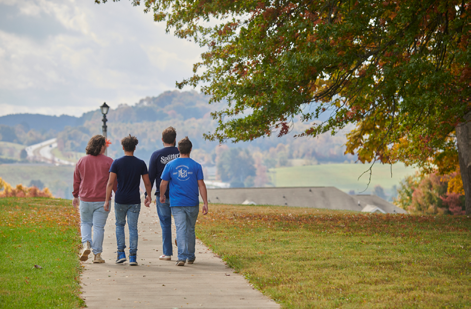 Four students walking on a sidewalk on the campus of LMU.