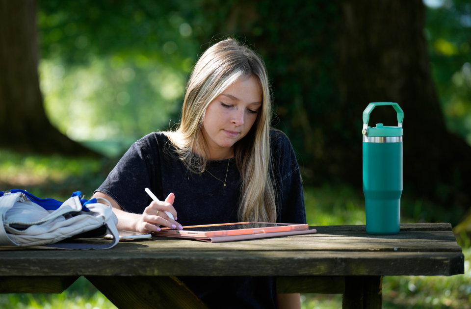 A student studying at a picnic table.