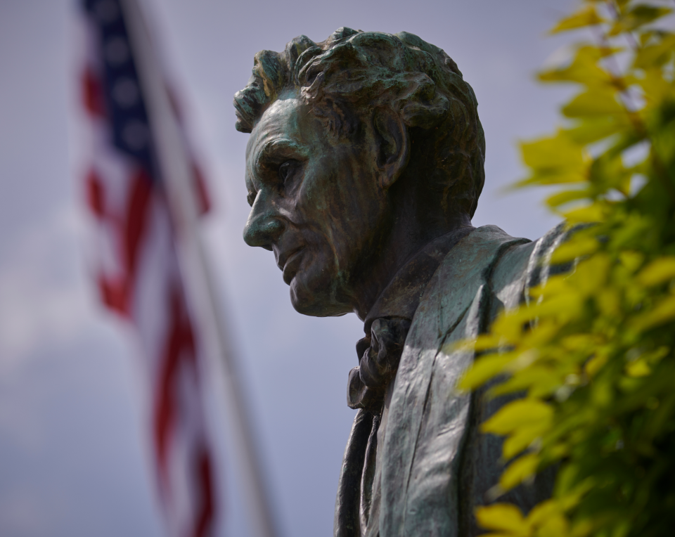 Abraham Lincoln statue with flag in the background. 